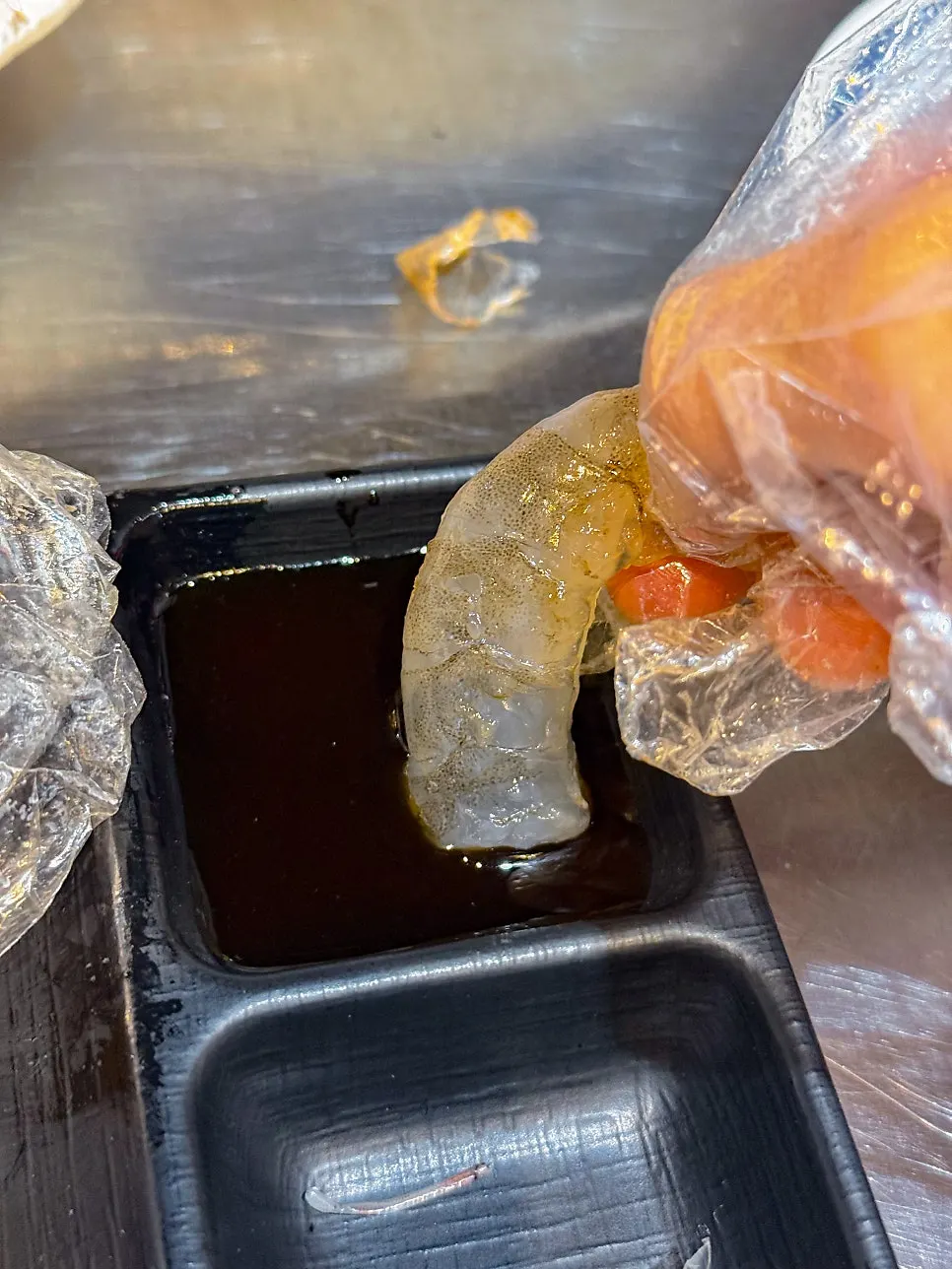 Hand-peeling raw shrimp sashimi to eat