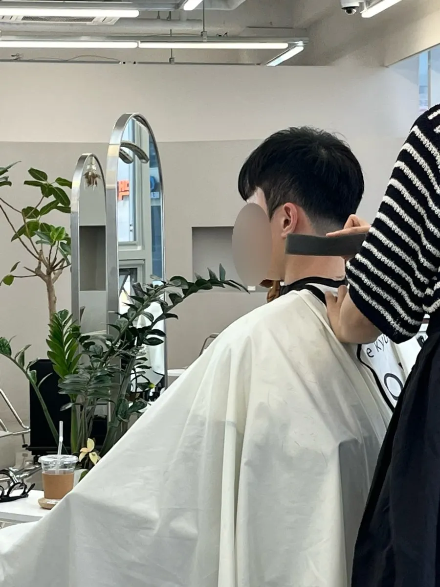 Designer Gawon performing the men's haircut