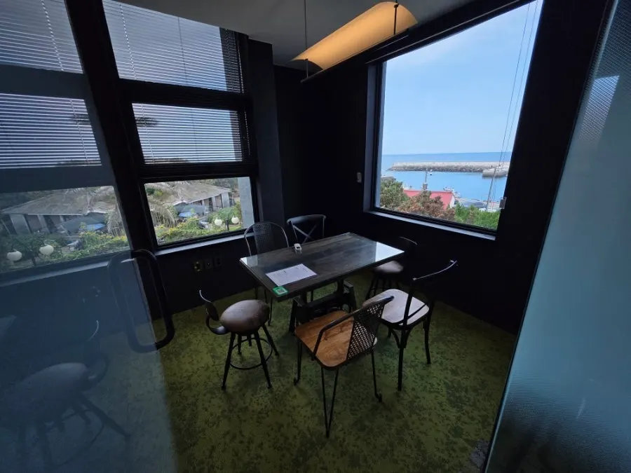 First-floor interior with sofa and bar seating by the full-length windows