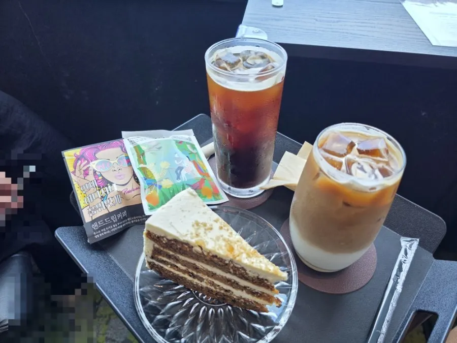 Table setting with iced americano, iced café latte, and carrot cake