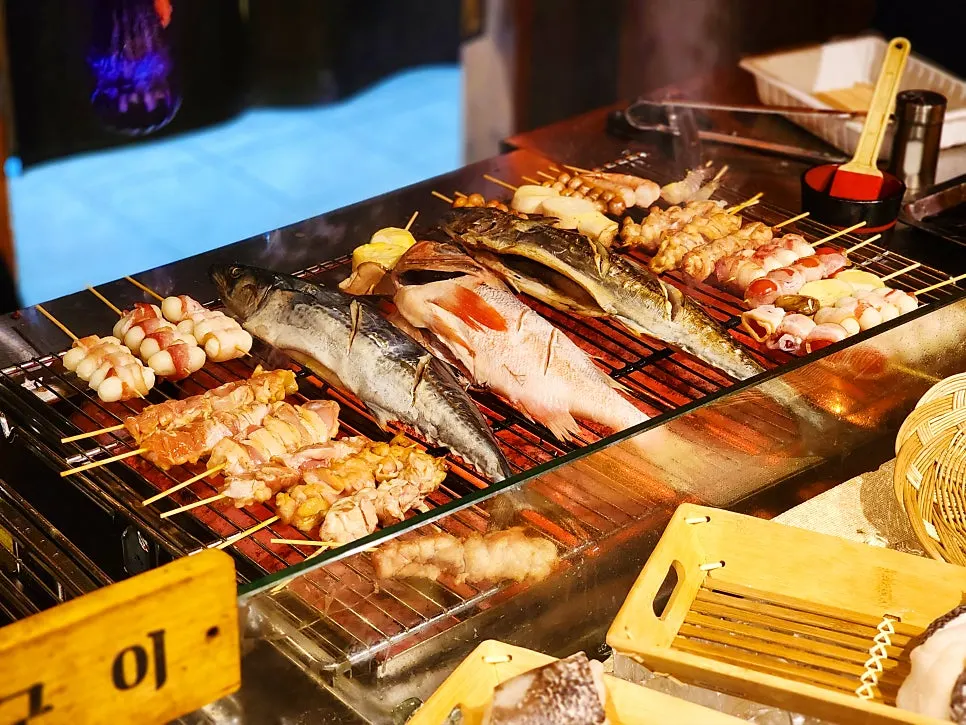 Fish and skewer ingredient display case in front of the bar seats