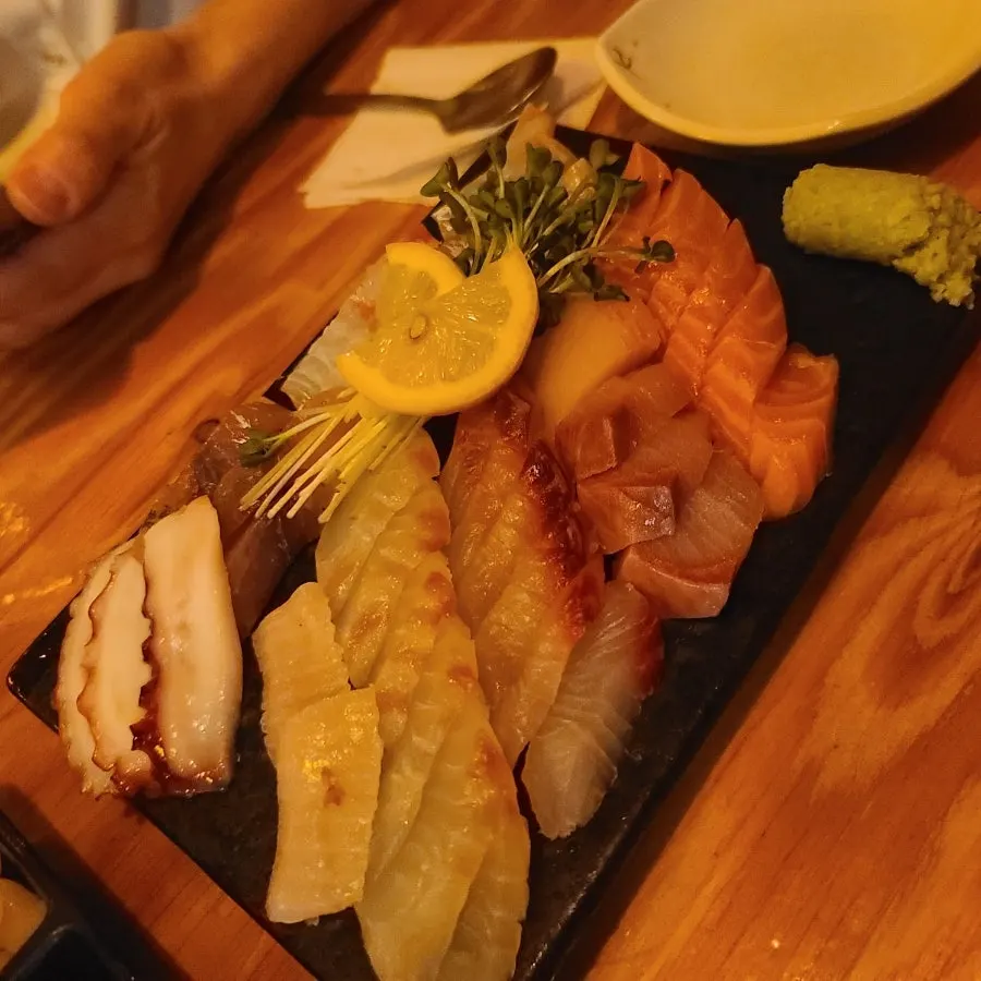 Mixed sashimi plate garnished with radish sprouts and lemon