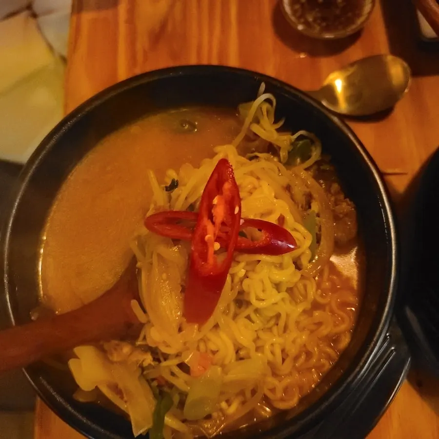 Finishing ramyeon topped with bean sprouts and red chili