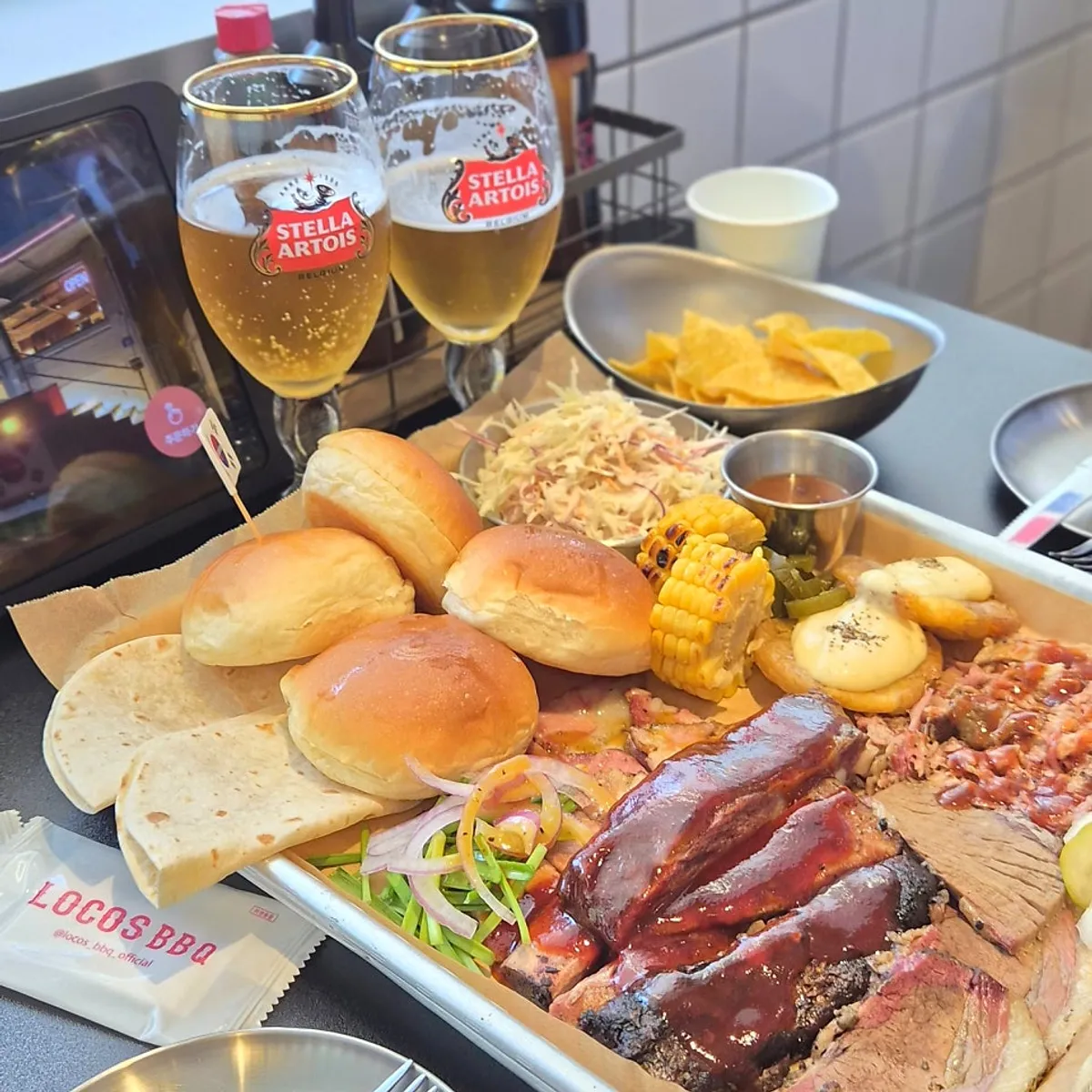 Barbecue spread served with tortillas and dinner rolls