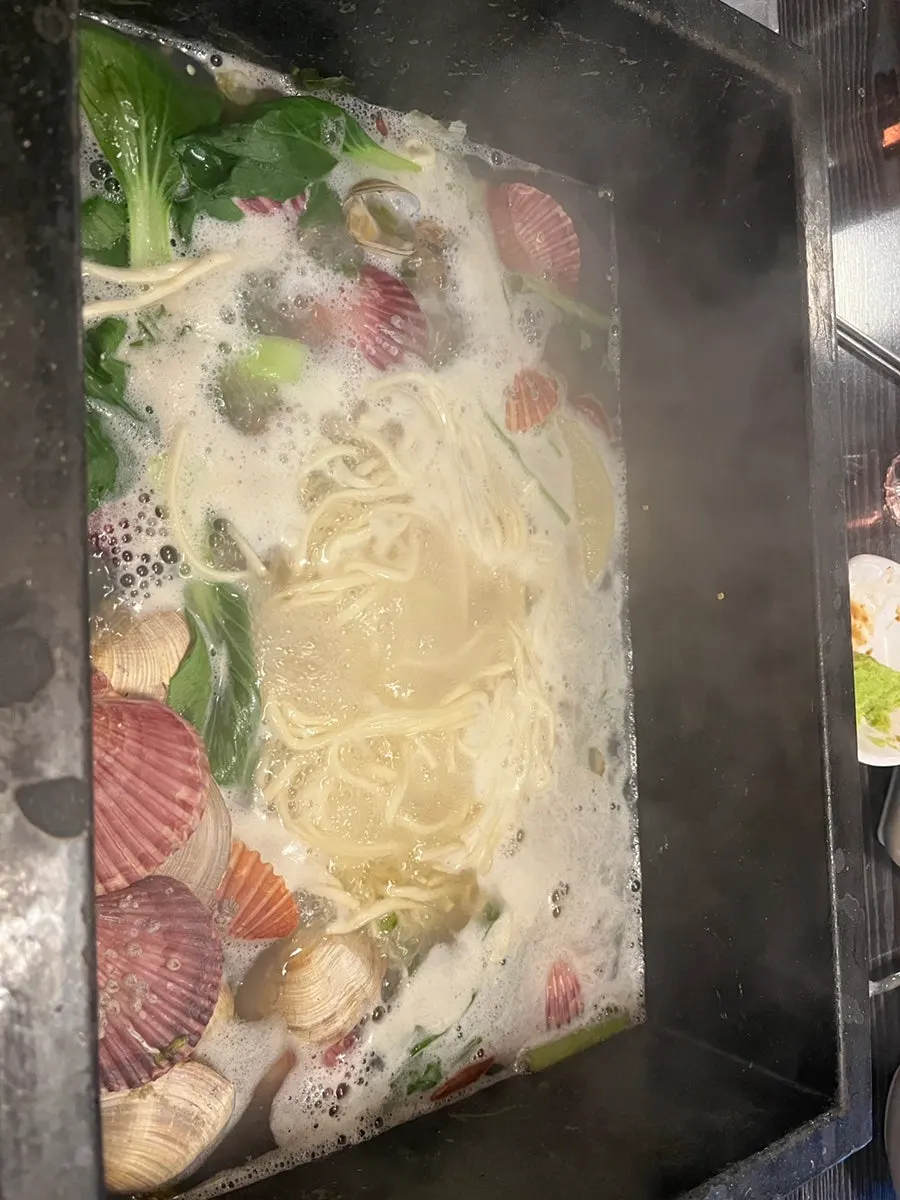 Kalguksu cooking in the steamed clam broth