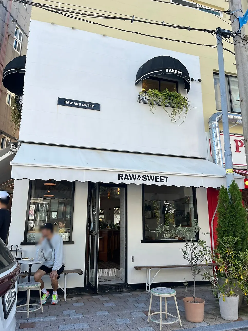 Low & Sweet Bakery's exterior with white walls and plants