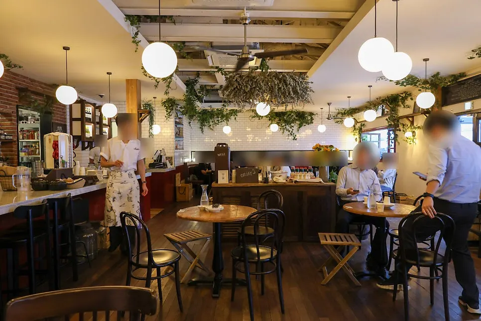 Low Five Anguk's interior with a mix of marble and wooden tables