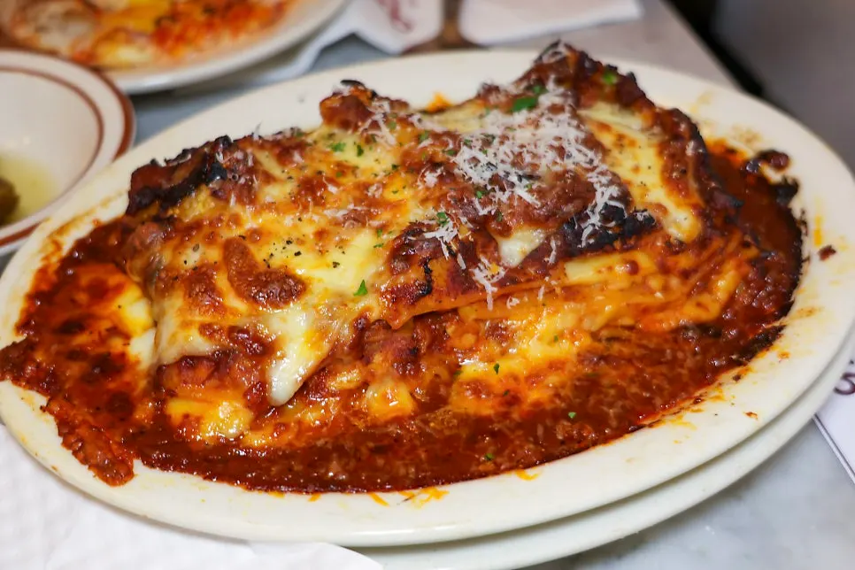 Cross-section of the lasagna cut with a fork, showing layers of cheese
