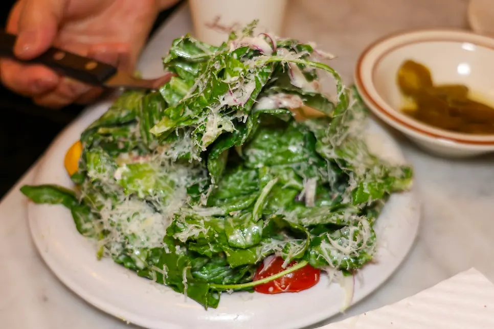 Caesar salad piled on top of the pizza