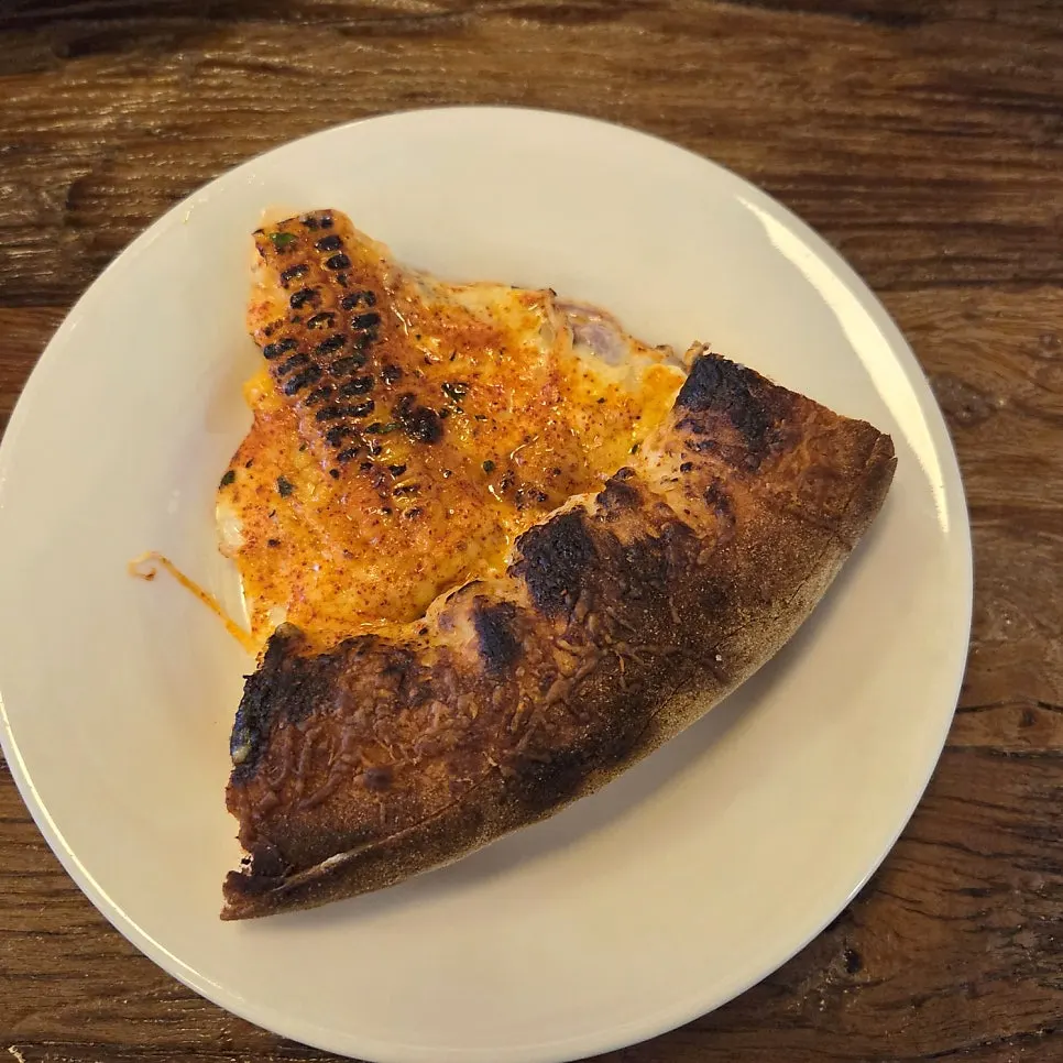 A slice of the half-and-half pizza with stretchy cheese