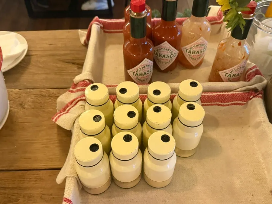 Self-serve bar with hot sauce and grated cheese