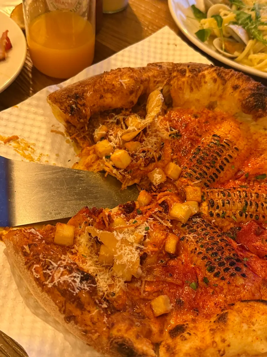 A slice of half-and-half pizza with stretchy cheese