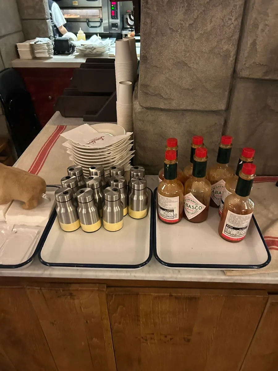 Parmesan cheese powder and hot sauce set on the table