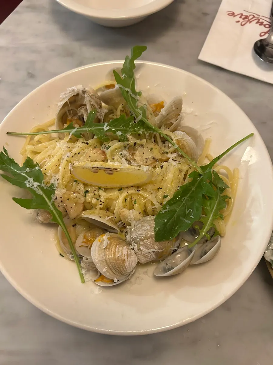 Vongole pasta topped with clams and arugula