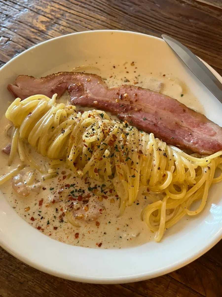 Alfredo cream pasta topped with grilled bacon