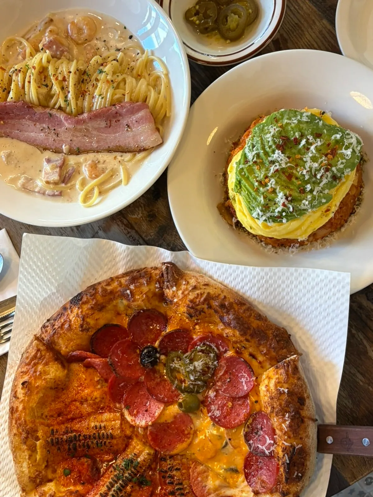 A spread of half-and-half pizza, pasta, and kimchi fried rice