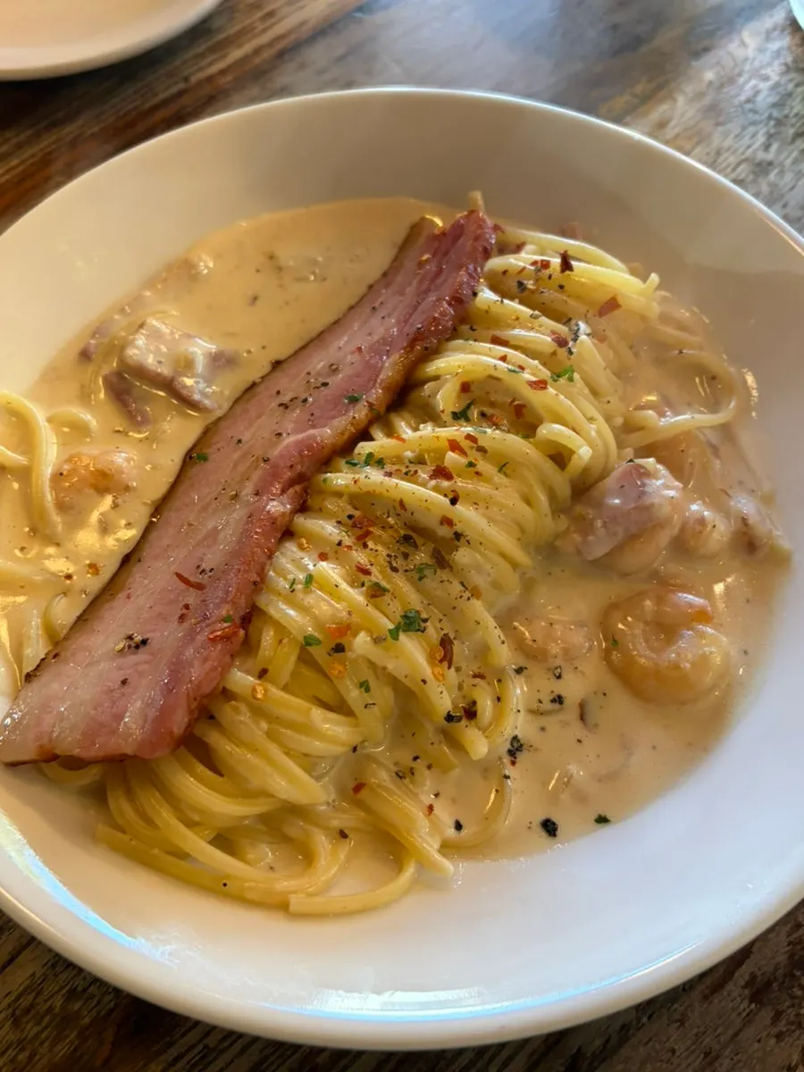 Alfredo cream pasta topped with grilled bacon