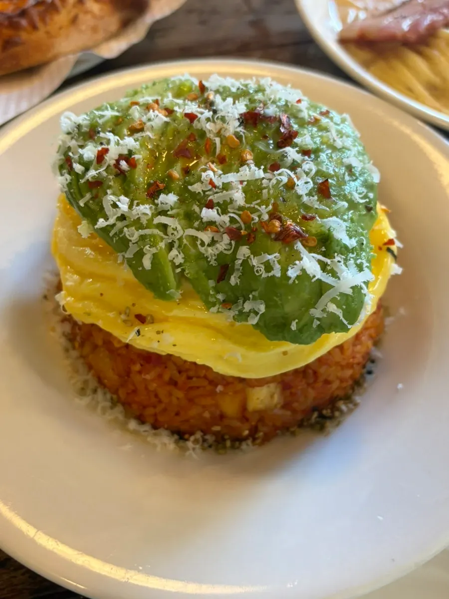 Kimchi fried rice topped with scrambled egg and avocado