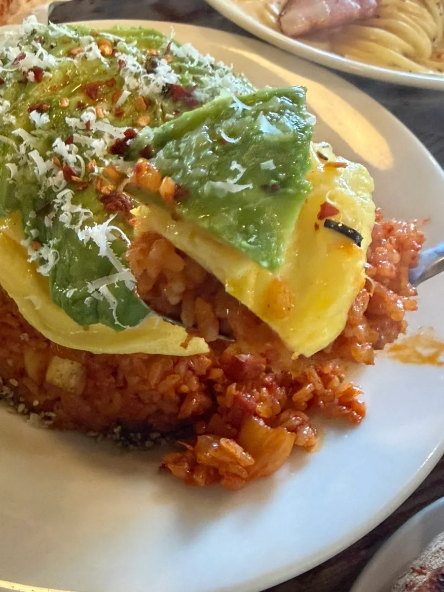 A scooped spoonful of avocado kimchi fried rice