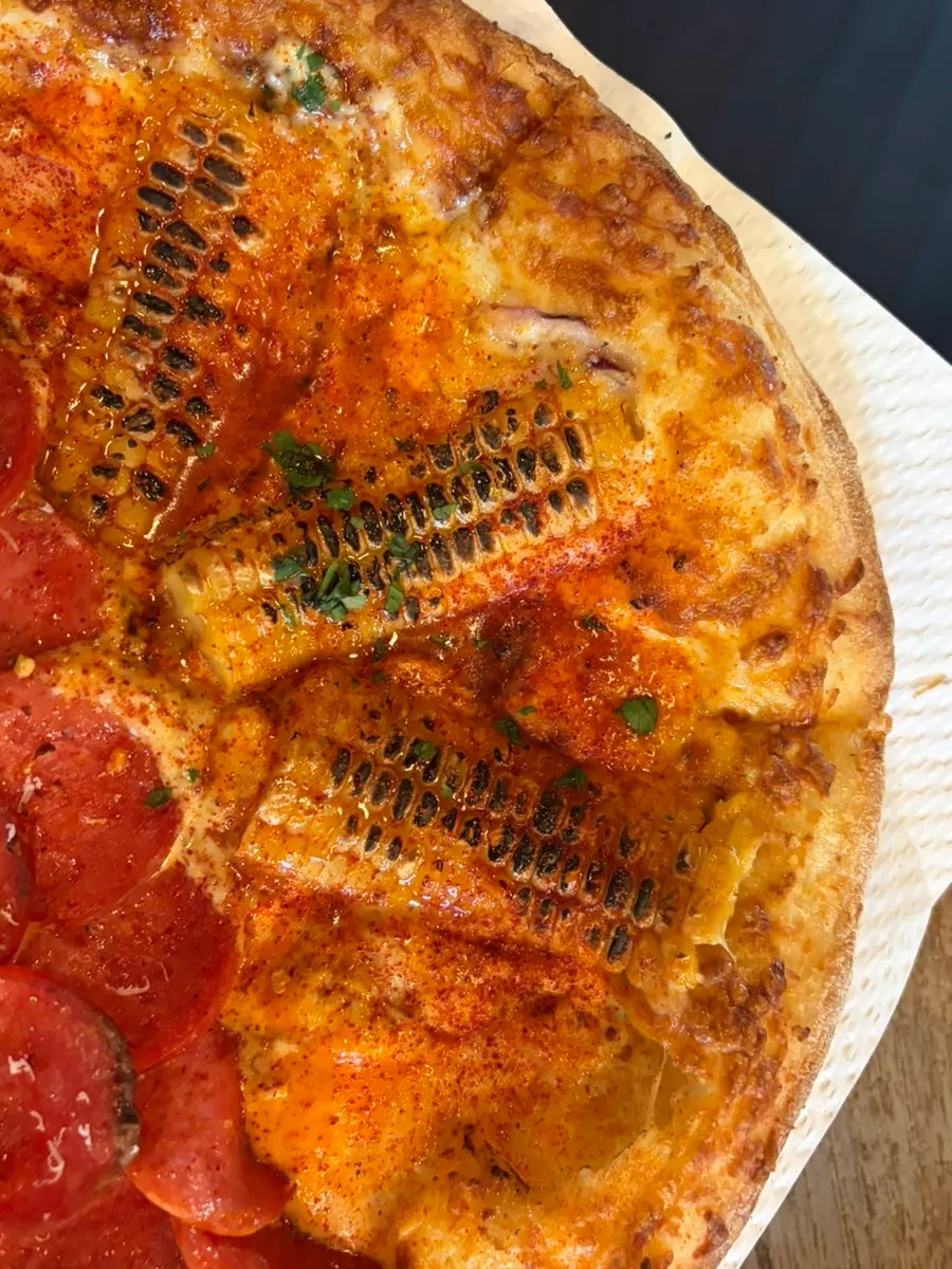 Lifting a slice of half-and-half pizza