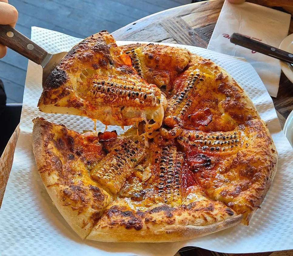 Corn pizza with a corn kernel topping every slice