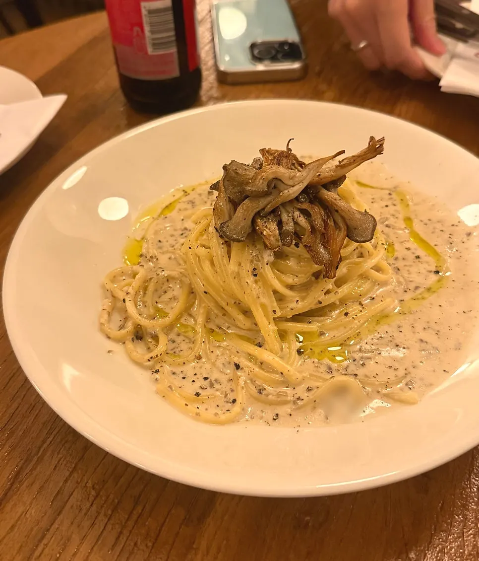 Close-up of truffle cream pasta topped with roasted oyster mushrooms