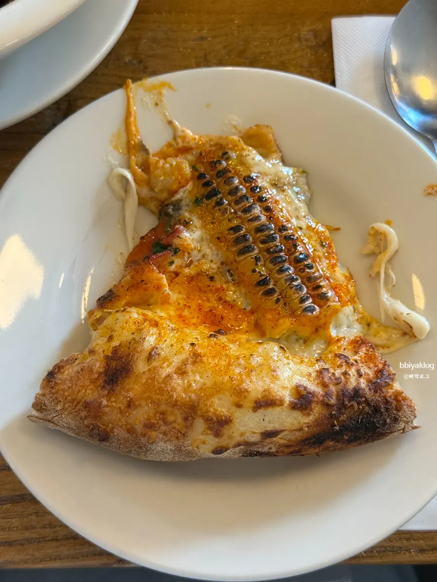 Slice of corn pizza with whole corn cross-sections on top