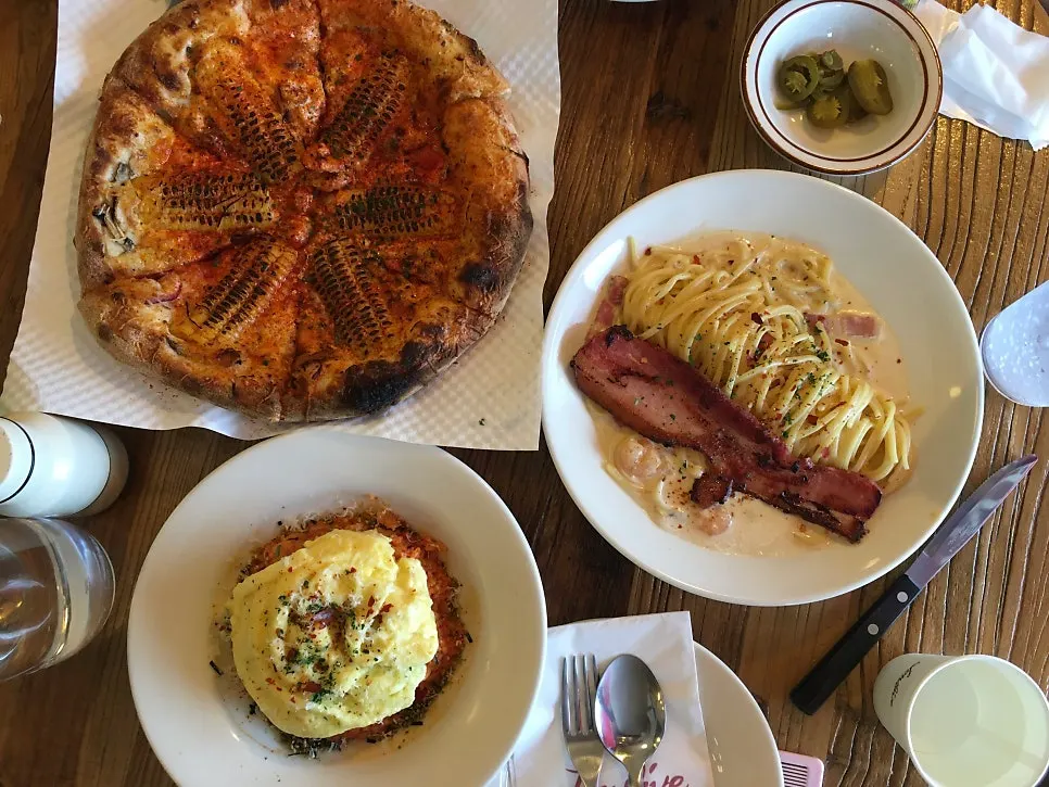 Table spread with corn pizza, pasta, and kimchi fried rice