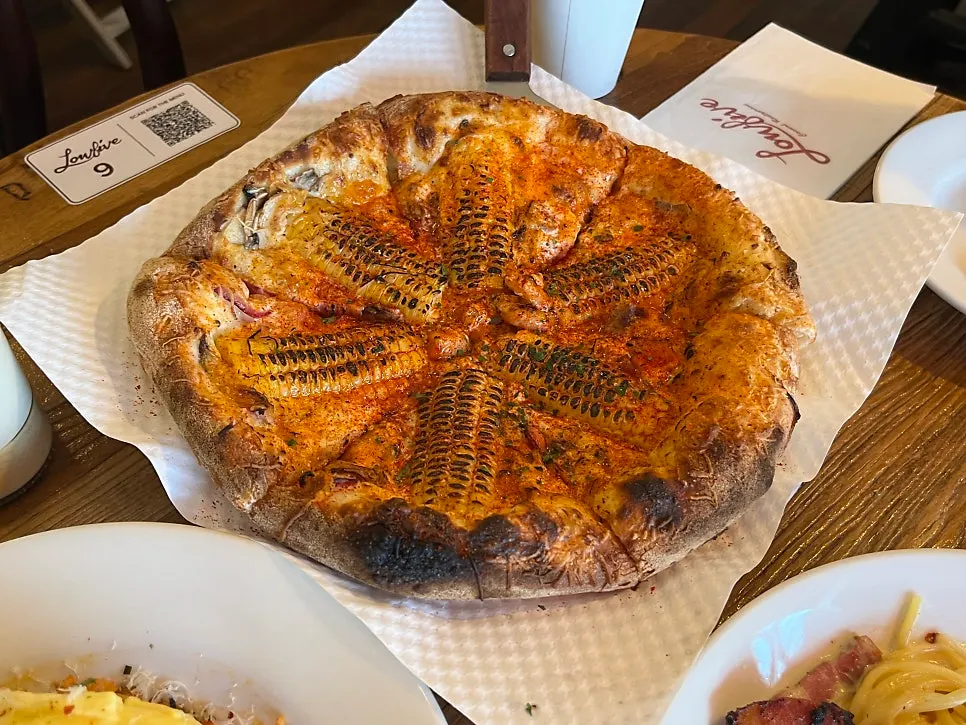 Corn pizza topped with grilled corn and chili shrimp