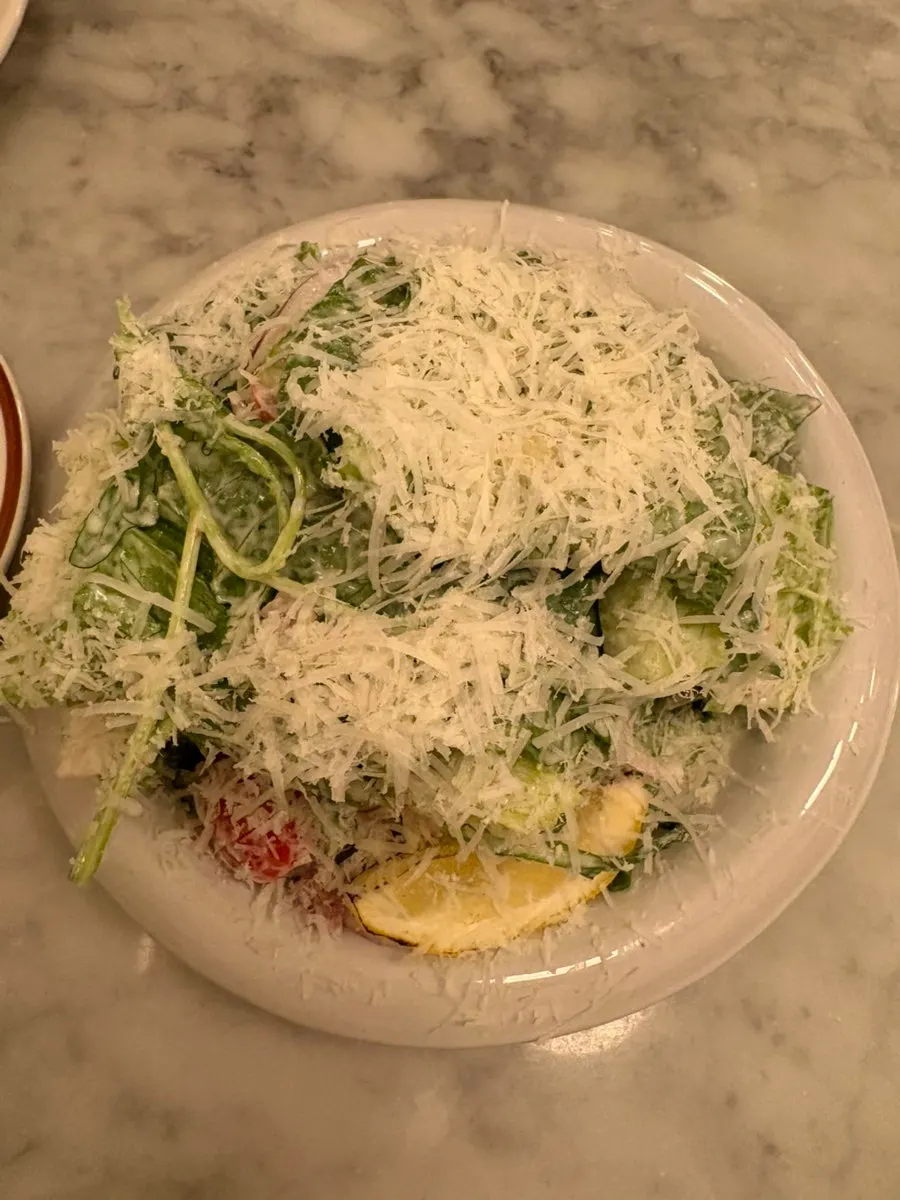 Caesar salad served alongside pizza and pasta
