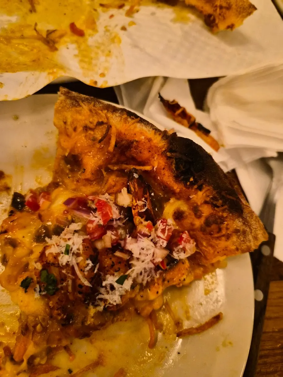 A pizza slice eaten all the way to the edge