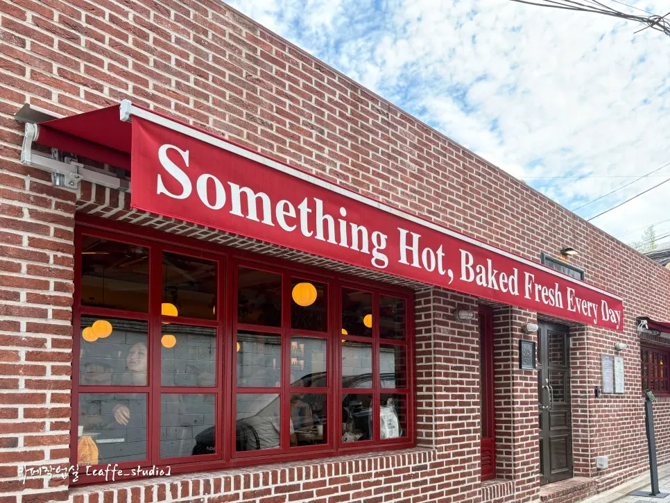 Red brick and red awning exterior of Low Five Anguk