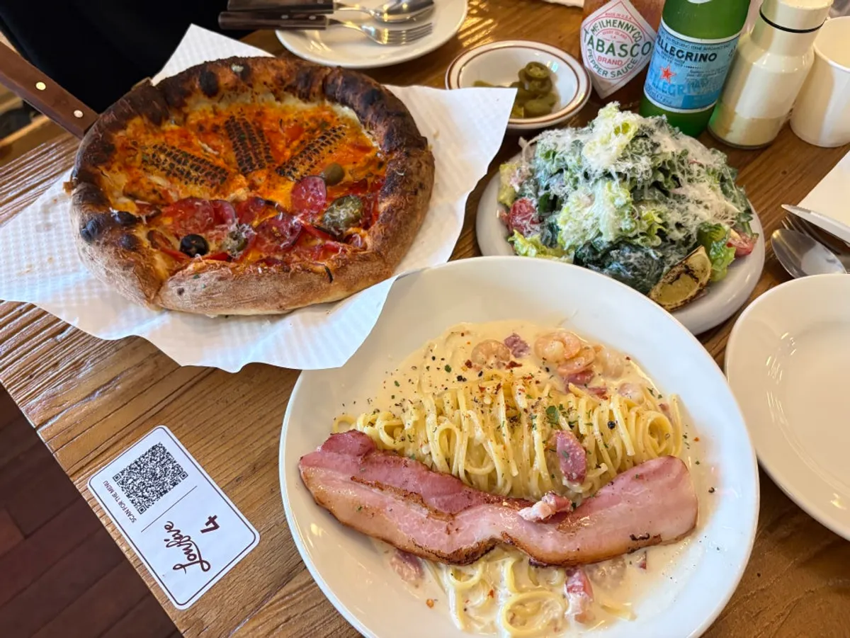 Full shot of the salad, half-and-half pizza, and cream pasta together