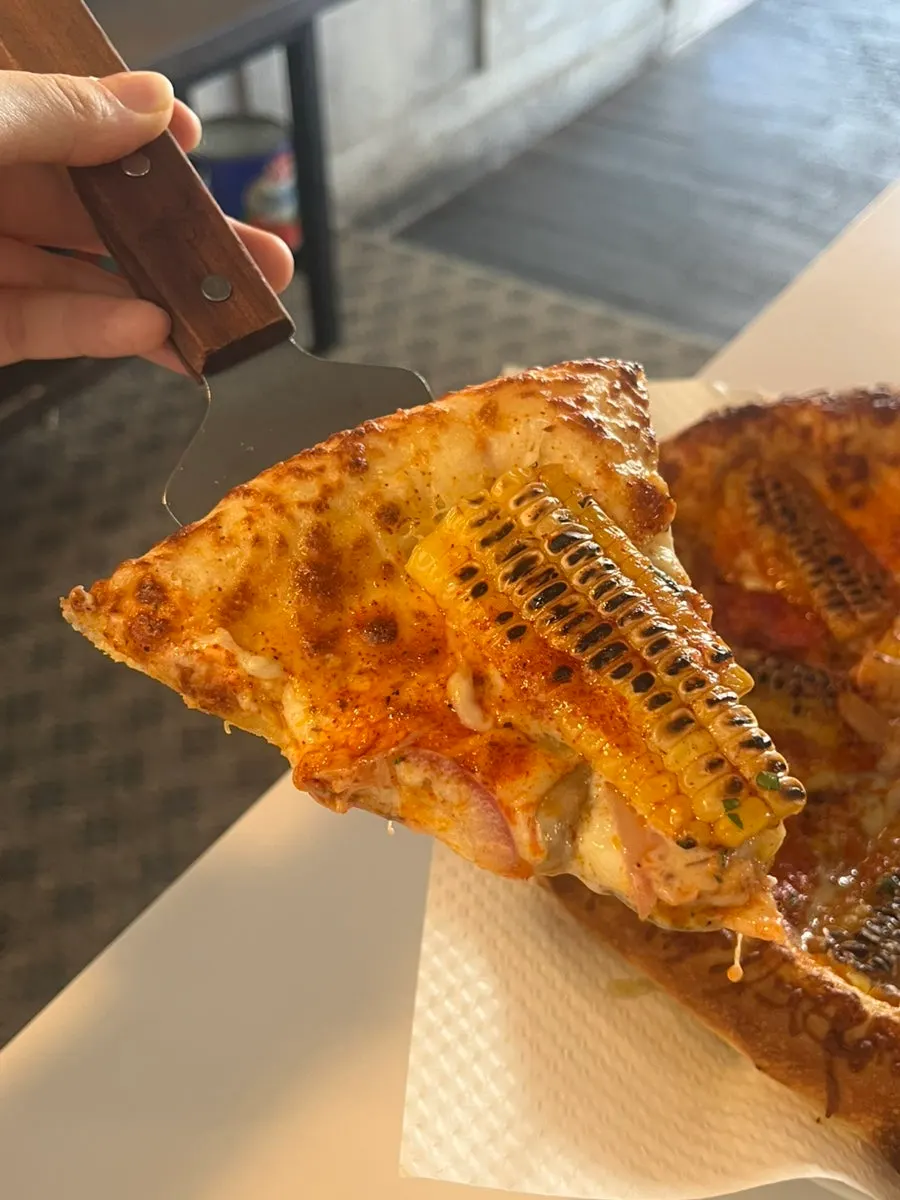 Corn pizza topped with whole corn kernels and cheese