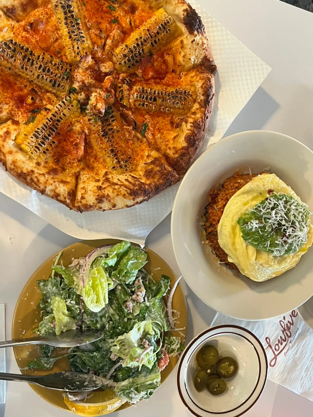 A full spread of avocado kimchi fried rice and corn pizza