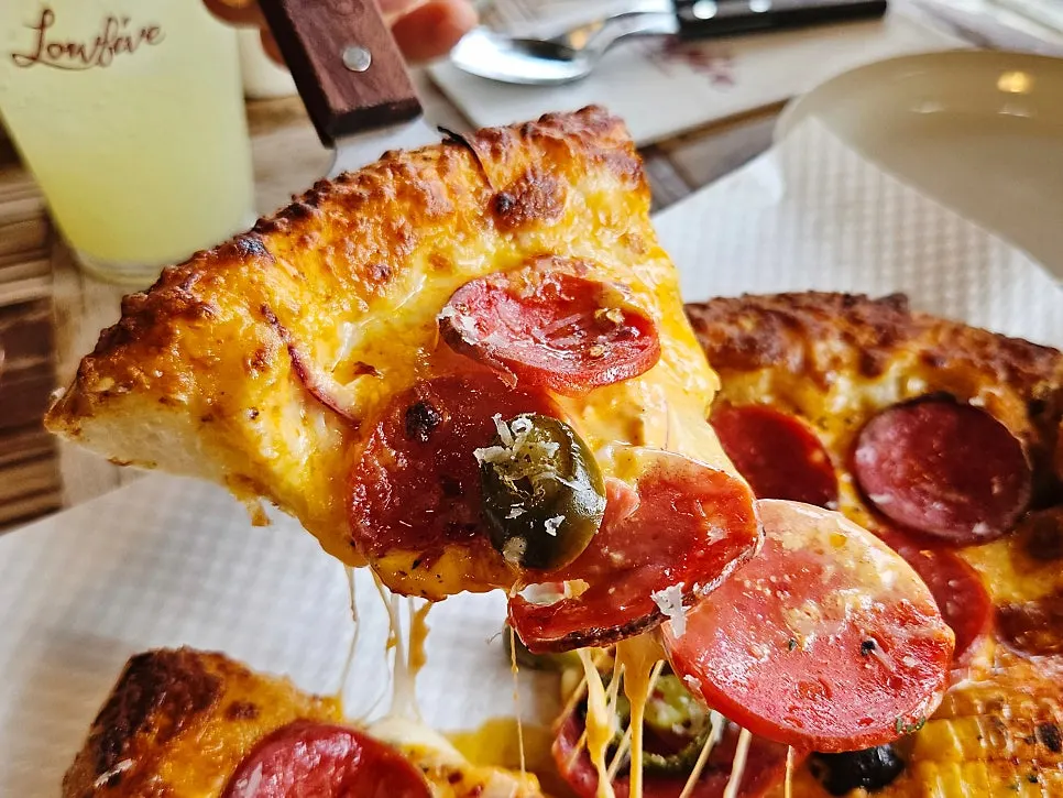 Corn pizza topped with whole corn kernels and truffle cream