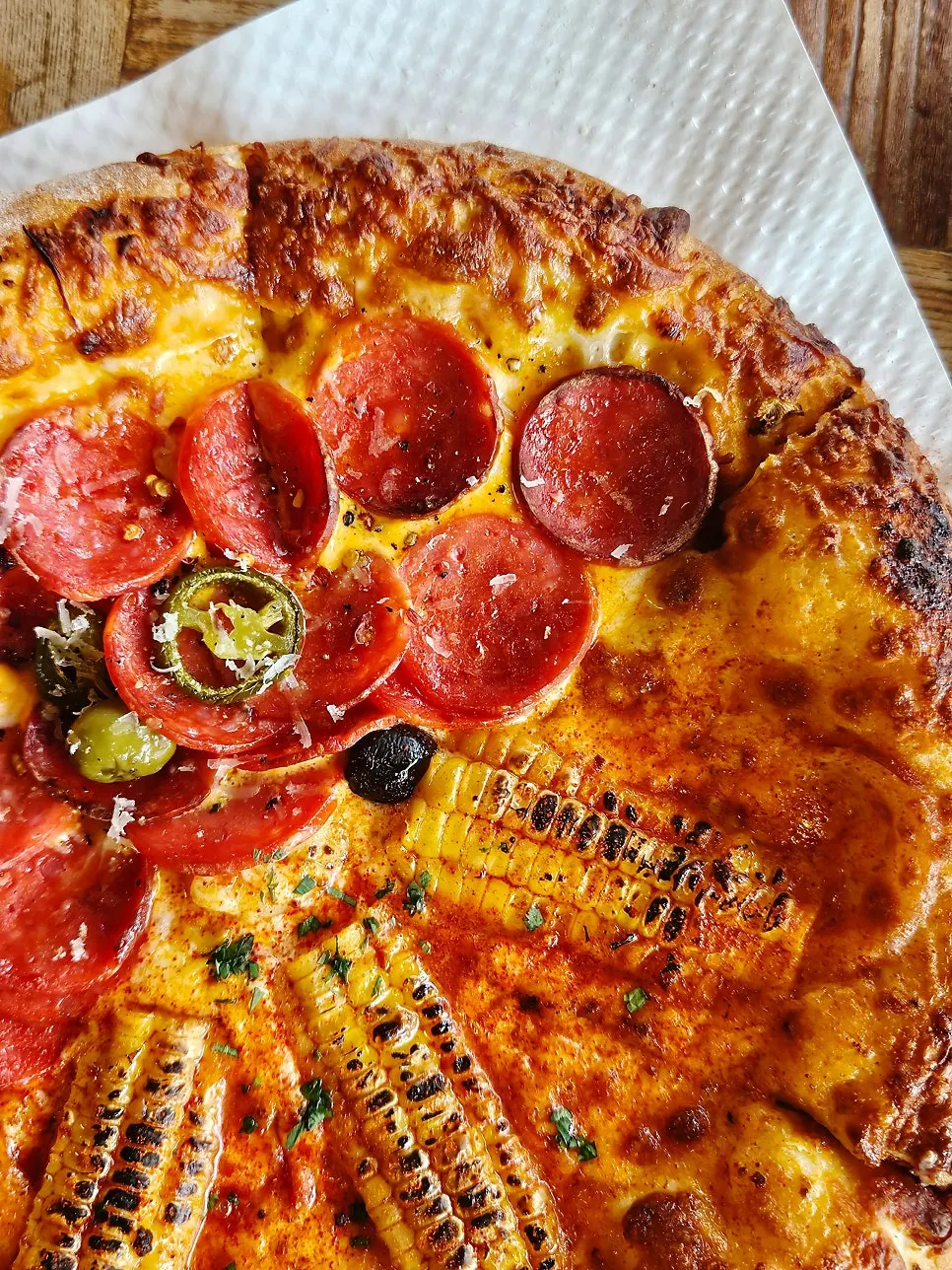 Pepperoni pizza topped with pepperoni, olives, and jalapeños