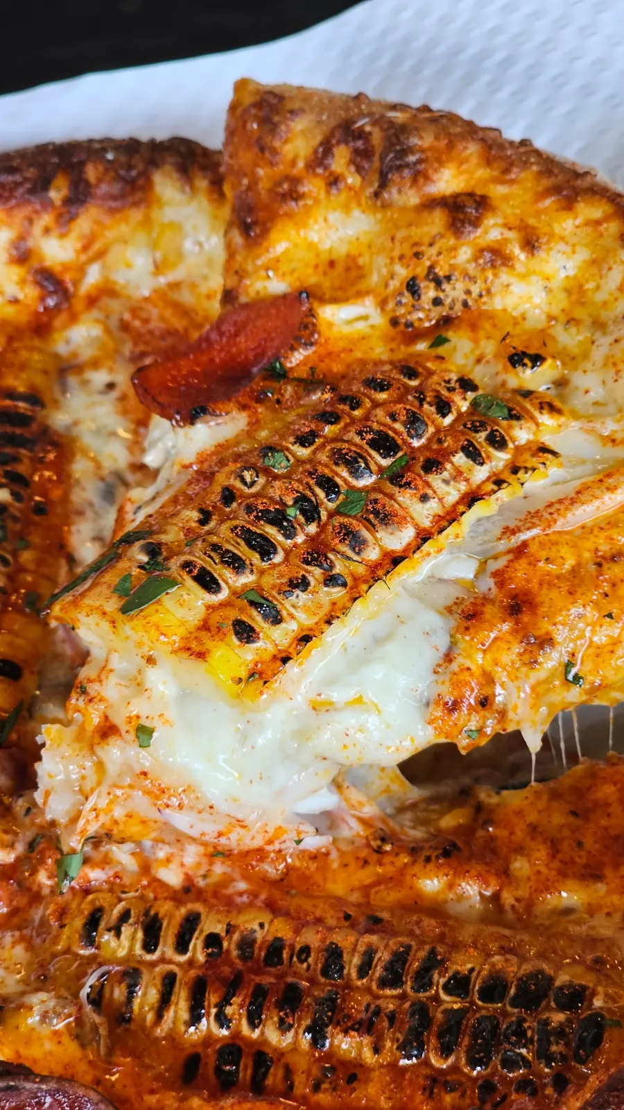 A slice of corn pizza topped with grilled corn