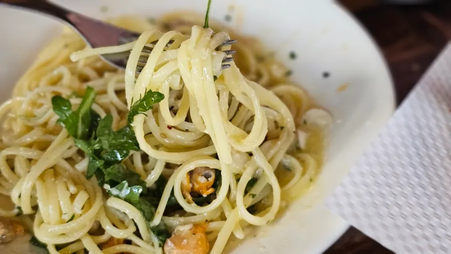 Clam pasta noodles topped with arugula