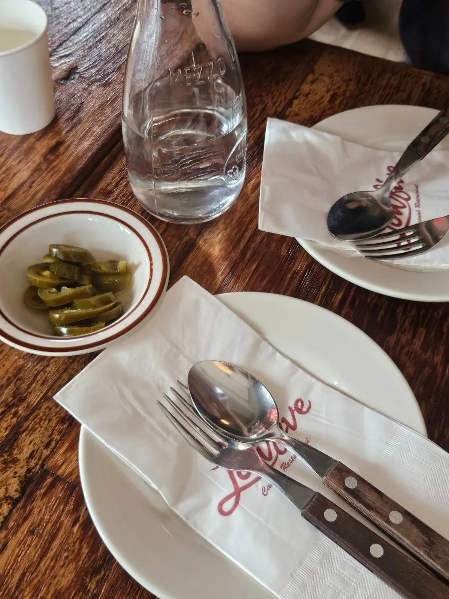 Small plate, utensils and jalapeños set on the table
