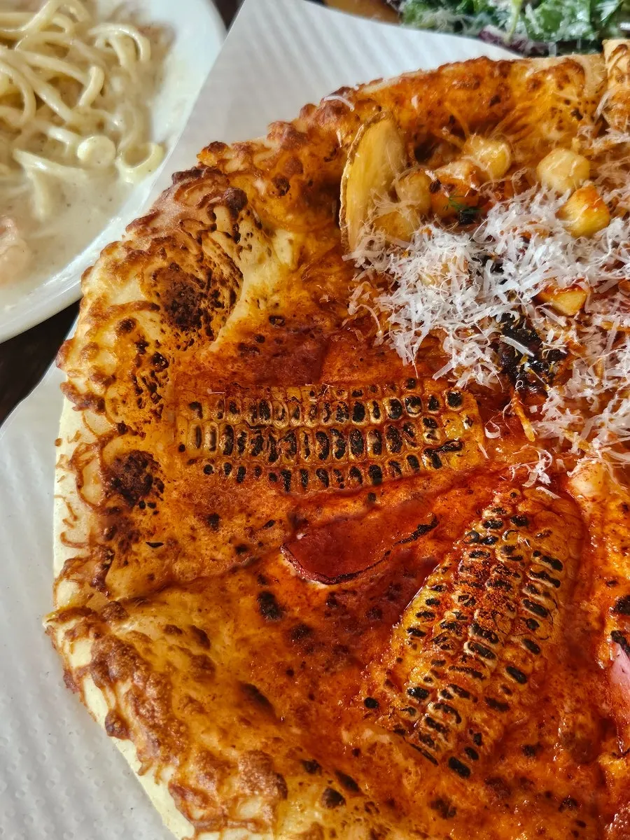 Holding a slice of hot chili potato pizza