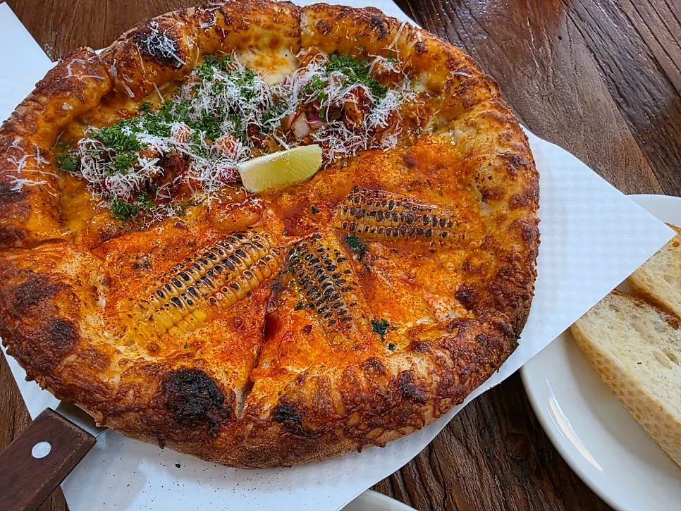 Half corn, half taco pizza on one plate