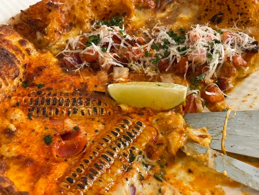 A single slice of corn pizza