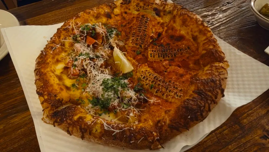 Dipping pizza into the pasta sauce