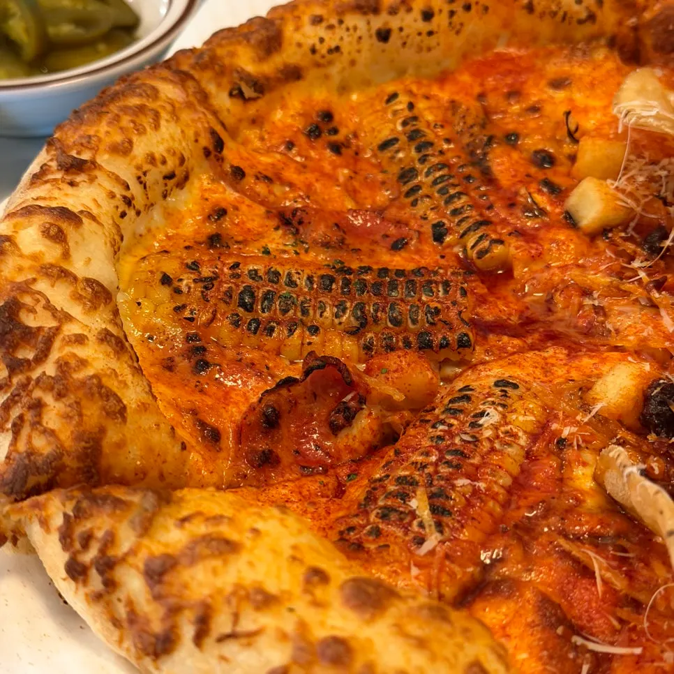 Corn pizza with a white truffle cream base