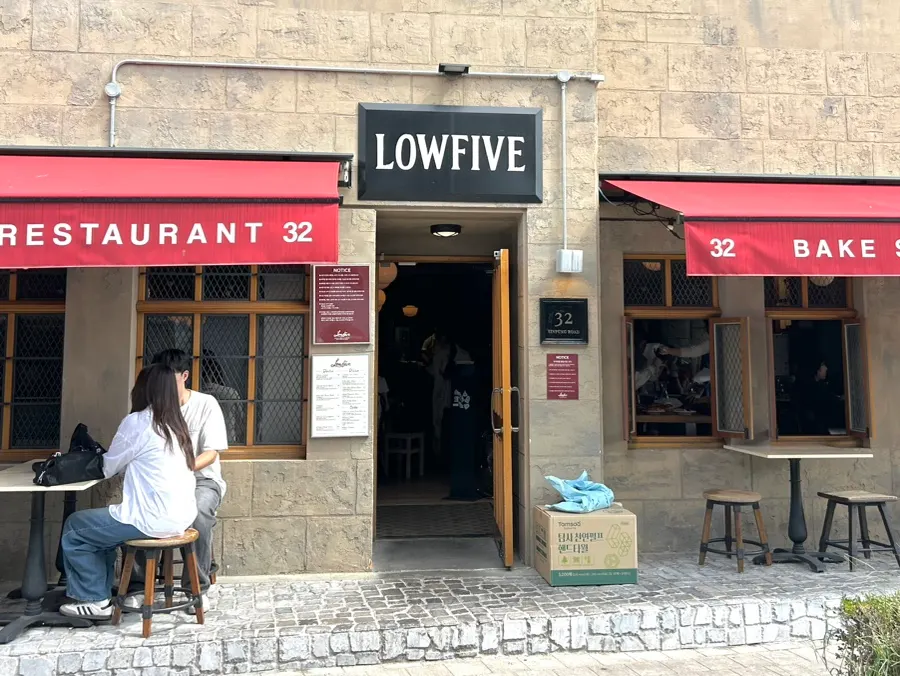 Beige-toned walls with a red awning on the exterior