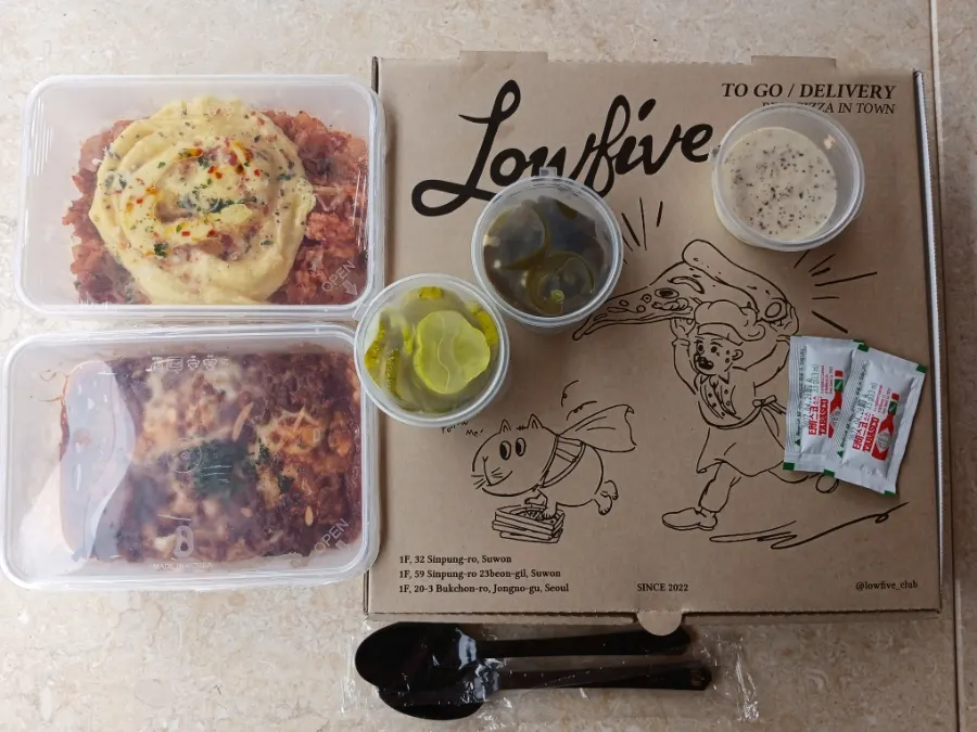Wrapped takeout containers of lasagna and kimchi fried rice