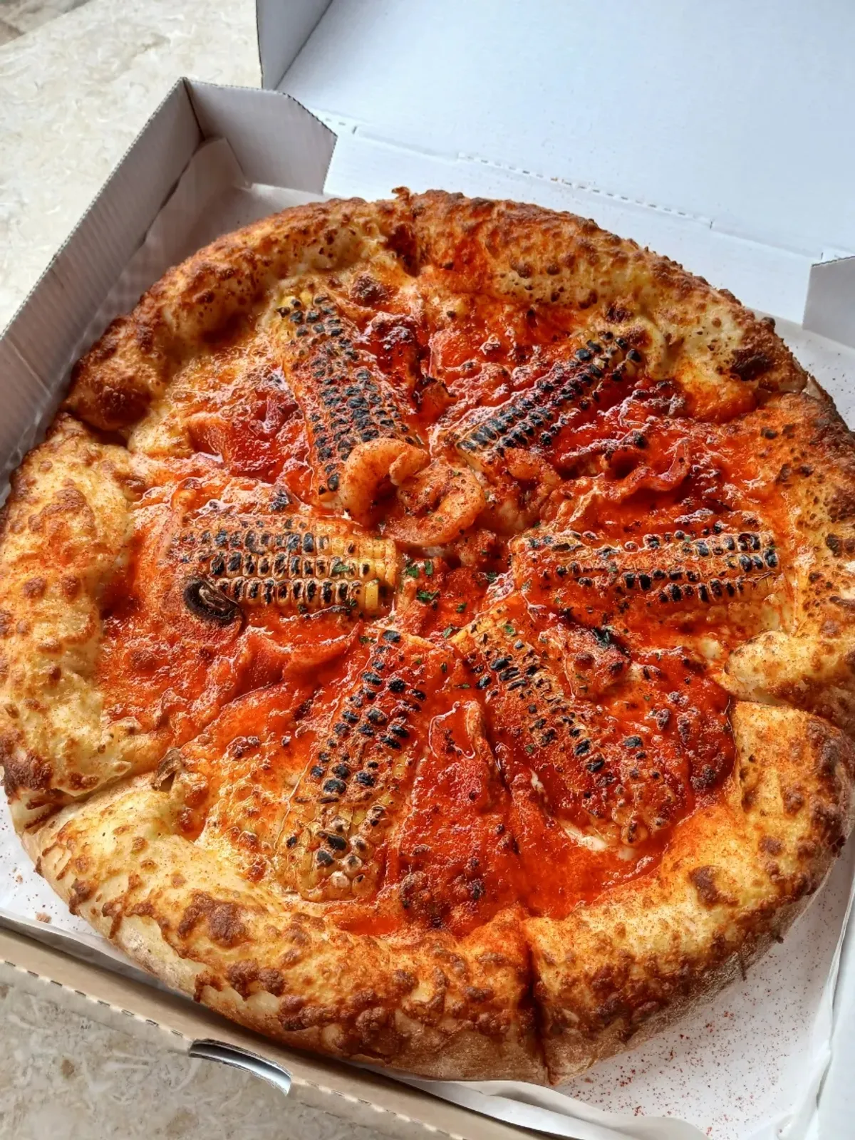Corn pizza packed in a pizza box
