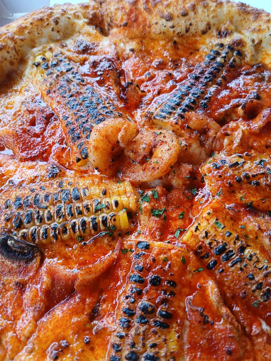 Wood-fired pizza topped with sweet corn and cream