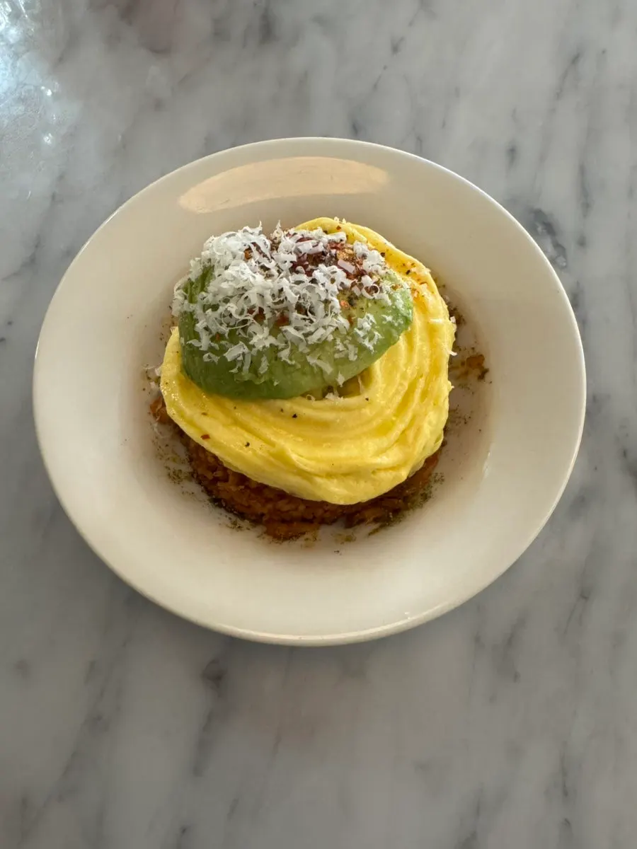 Close-up of kimchi fried rice topped with scrambled egg and avocado